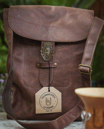 Matera patria cuero vacuno natural con apliques de bronce y bolsillo externo porta celular